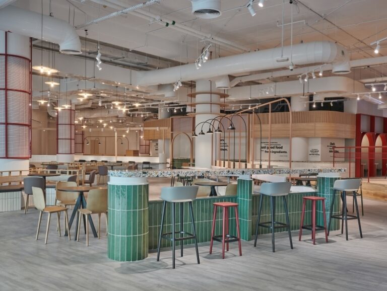 Contemporary sustainable dining area at Picnic Square in Dubai featuring natural materials, open ceilings, and mixed seating designed by Summertown Interiors.