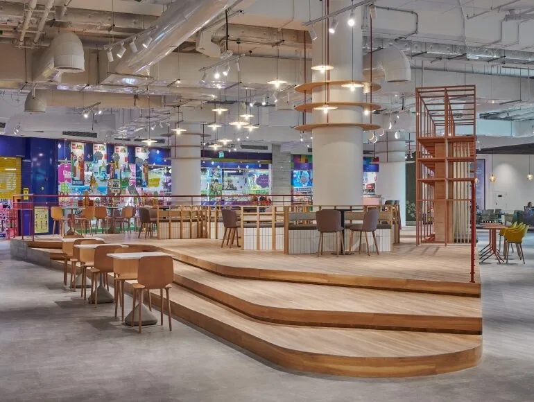 Tiered dining platform at Picnic Square in Dubai featuring warm timber finishes, modern seating, and sustainable F&B fit-out detailing by Summertown Interiors.