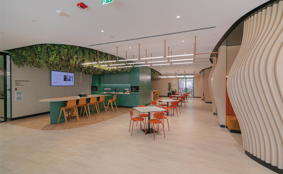 Modern office pantry with biophilic ceiling, green cabinetry, wave-like timber slat feature wall, and flexible dining layout designed by Summertown Interiors