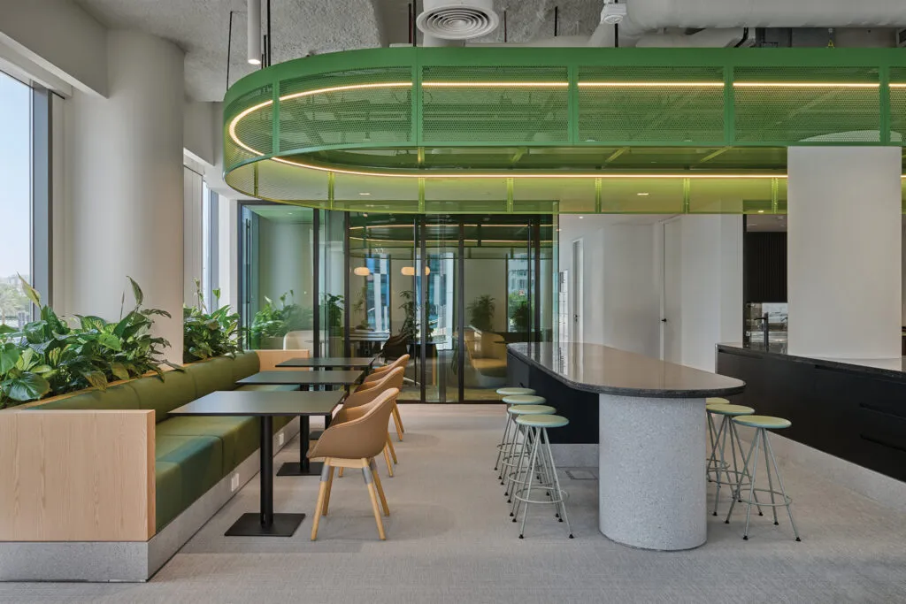 Sustainable office fit-out in Dubai featuring a biophilic pantry and breakout space with green seating, natural light, and modern finishes at Schneider Electric